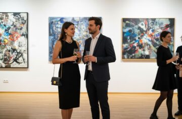 Elegancka para rozmawia podczas wieczornego wernisażu w nowoczesnej galerii sztuki.