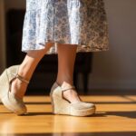 Para modnych koturn na drewnianej podłodze, kobieta w letniej sukience, ostrość na fakturze i wysokości butów